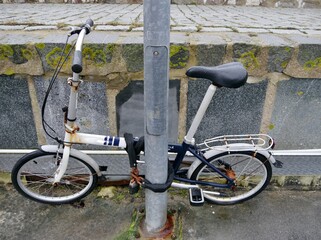 Altes Fahrrad an Pfahl angeschlossen