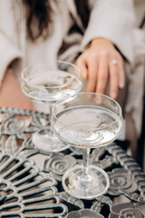 Elegant Hand with Engagement Ring and Champagne Glasses on Ornate Table