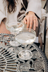 Elegant Hand with Engagement Ring and Champagne Glasses on Ornate Table