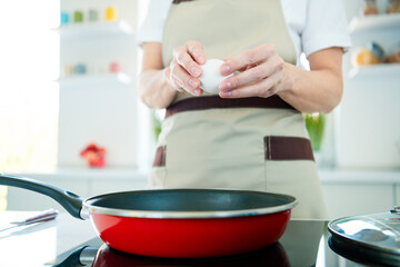 Charming mature woman preparing a homemade meal in bright kitchen with focus on professional...