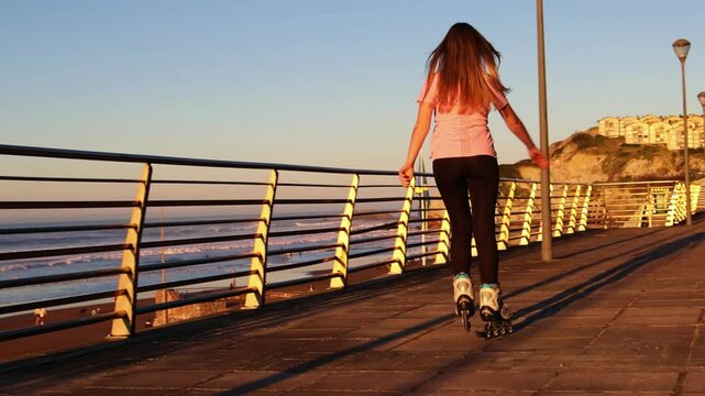 Woman enjoying inline skating along the beach at sunset