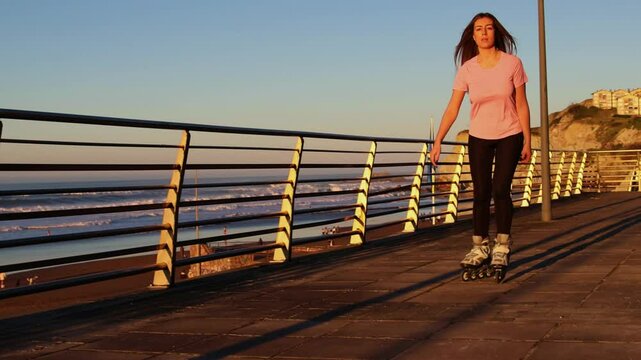 Woman enjoying inline skating by the beach at sunset