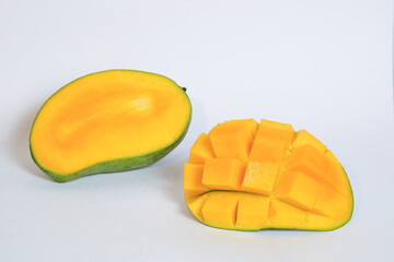 Yellow ripe mango slices isolated on white background.Copy space for text.Source of vitamin c.Fresh fruit concept.Mango sliced in squares.For graphic design or banner background