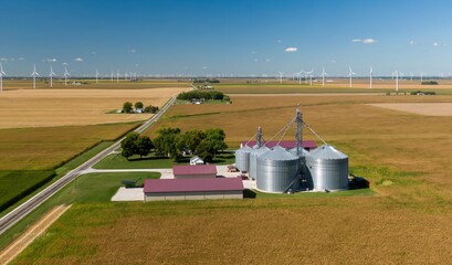 Aerial view of agricultural silos and wind turbines in a rural landscape. Farmers store crops in silos. Sustainable energy and agriculture. , Brookston, Indiana, United States © Zenstratus