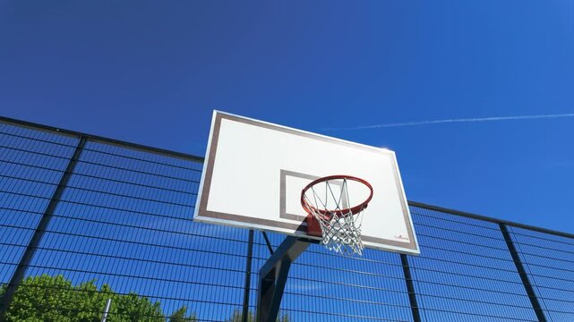 Low angle of Basketball board with basket hoop on playground under a blue sunny sky