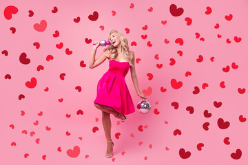 Full length photo of shiny pretty girl dressed sexy outfit rising disco ball singing karaoke dancing isolated pink color background