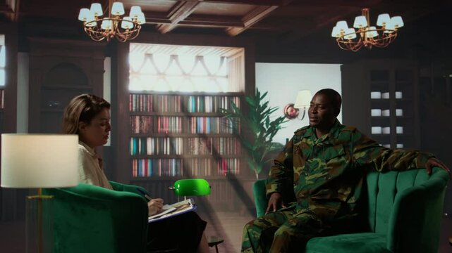 Portrait of war veteran meeting with a therapist to discuss about grief and distress due to PTSD and battle trauma, shell shock and mental disorder. Depressed trooper at counseling. Camera B.