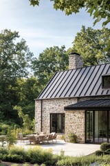Modern stone house with outdoor seating surrounded by lush greenery in bright daylight