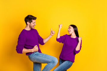 Obraz premium Portrait of delighted two married people raise fists scream yeah celebrate victory wear red sweater denim jeans isolated over yellow background