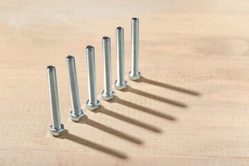 Row of tap bolts on wooden background