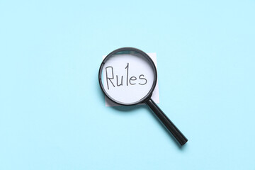 Paper with word RULES and magnifier on blue background