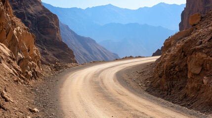 Curving dirt road through mountainous desert landscape