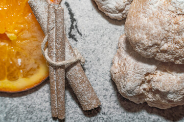 orange cookies and cinnamon powdered sugar on black background kitchen concept