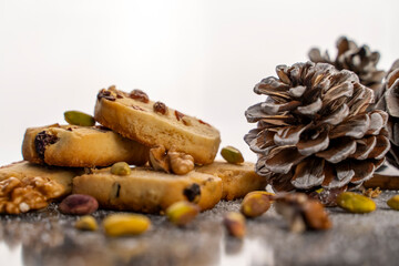 Pine nut cookies on black and white background with pine cones next to them kitchen concept