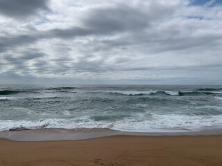 Beach scene with waves breaking on the shore.