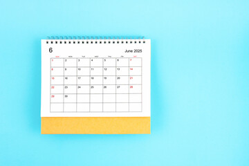June 2025, Monthly desk calendar for 2025 year on blue background.