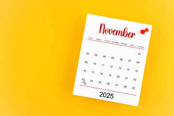 November 2025 calendar page with red push pin on yellow background.