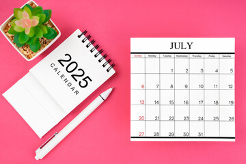 White calendar for July 2025 and pen on pink background, planning concept.