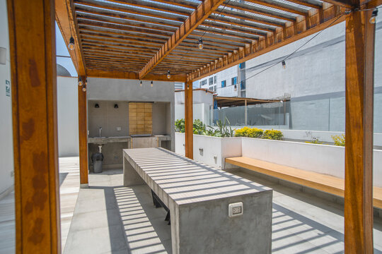 zona de reuniones y area de parrillas en terraza de departamento con mesa comedor