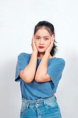 An Asian woman showing anxious expression with both hands on his head isolated on white background