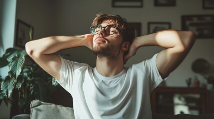 Obraz premium Young Man Relaxing Indoors Wearing Glasses
