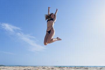 Mujer joven saltando de emoción porque esta feliz y divertida, con un sensacional día de...