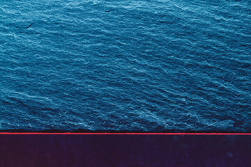 Abstract blue rocky textured slate with red border.