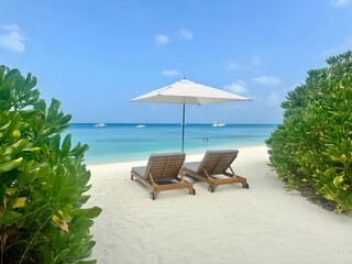 lounge chairs on the beach in the maldives