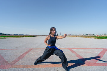Chica joven luchadora de artes marciales en el paisaje infinito y minimalista de una pista de...