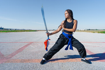 Chica joven luchadora de artes marciales en el paisaje infinito y minimalista de una pista de...