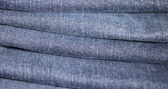 new blue denim fabric for the production of clothing and other items, folded fabric group, the details of a piece of sturdy denim fabric for the production of clothing