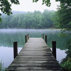 Wooden Dock Extending Into Misty Lake Surrounded By Lush Green Trees
