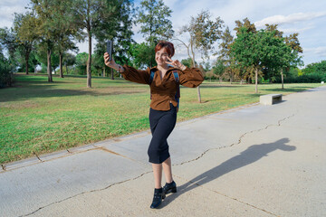 Chica joven atravesando un parque de camino al trabajo, instituto o universidad, un día soleado de...