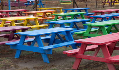 chairs in a park, colored benches, wet benches, colorful, many colored benches
