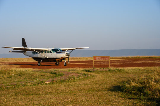 Fototapeta Airplane on the dirt airstrip at the Mara Serena Air Strip in the Maasai Mara National Reserve, African wildlife adventure safari in Kenya 
