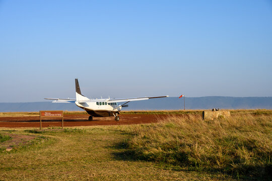 Airplane on the dirt airstrip at the Mara Serena Air Strip in the Maasai Mara National Reserve, African wildlife adventure safari in Kenya
