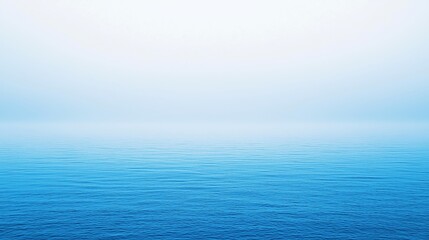 Fototapeta premium Expansive blue ocean under a serene sky at dawn with gentle waves reflecting soft light