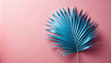 Fototapeta premium Vibrant Teal Palm Leaf on Soft Pink Background, Ideal for Summer Designs
