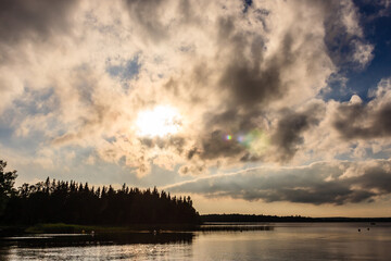 A cloudy sky with a sun shining through the clouds