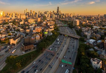 Chicago's I-90 highway at sunset, showing heavy traffic and the city skyline. Urban sprawl and...