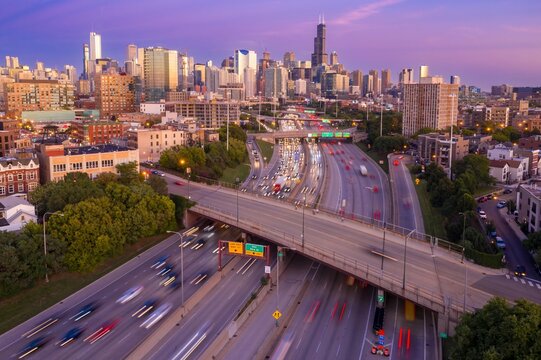 Chicago highway traffic at sunset. Busy I-90/94 interchange, cars blurred in motion. City skyline in background. Interstate 90, Chicago, Illinois, United States