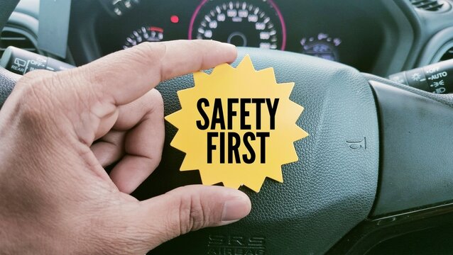 car steering wheel and paper with the word SAFETY FIRST. the main concept of safety in driving