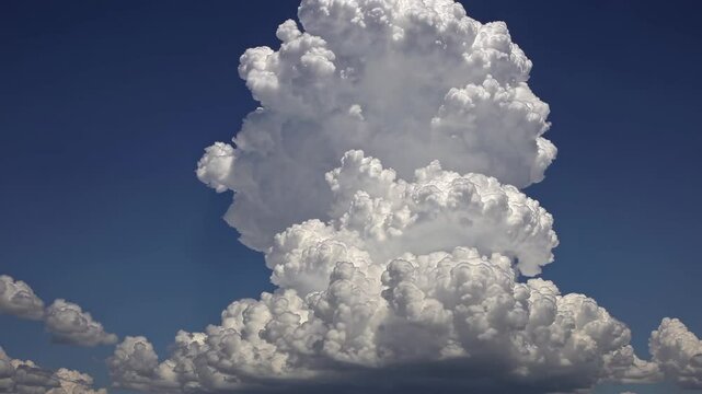 Majestic cumulus clouds build up in the blue sky over the countryside during a summer afternoon