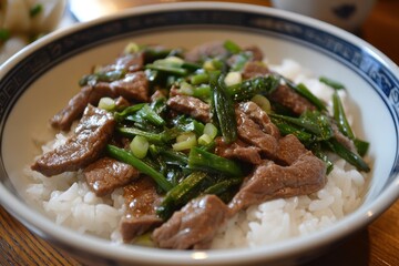 Beef and scallion stir-fry served over rice in a bowl. A delicious and healthy Asian-inspired meal, perfect for a quick lunch or dinner.