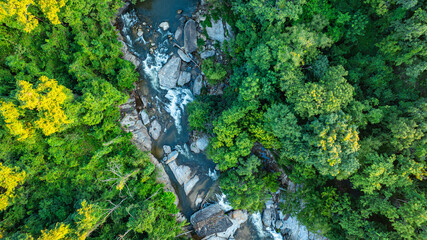 Mae Klang Waterfall in Chiang Mai..A stunning aerial view of a cascading waterfall surrounded by...