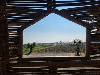 The tightly woven bamboo walls have geometric windows that offer views of the landscape. Woven bamboo wall