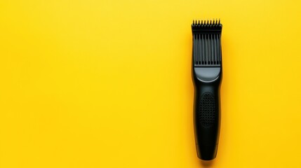 Obraz premium Black electric hair clipper on yellow background.