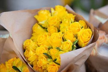 A view of bouquets of yellow roses, on display at a local farmers market.