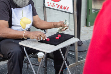 A view of a person offering a shell game to passersby.