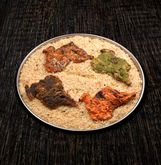 Mandi biryani rice with four variety flavoured fried chicken, Green chilli, pepper, honey and Alfahm chicken served in a large plate for family or group